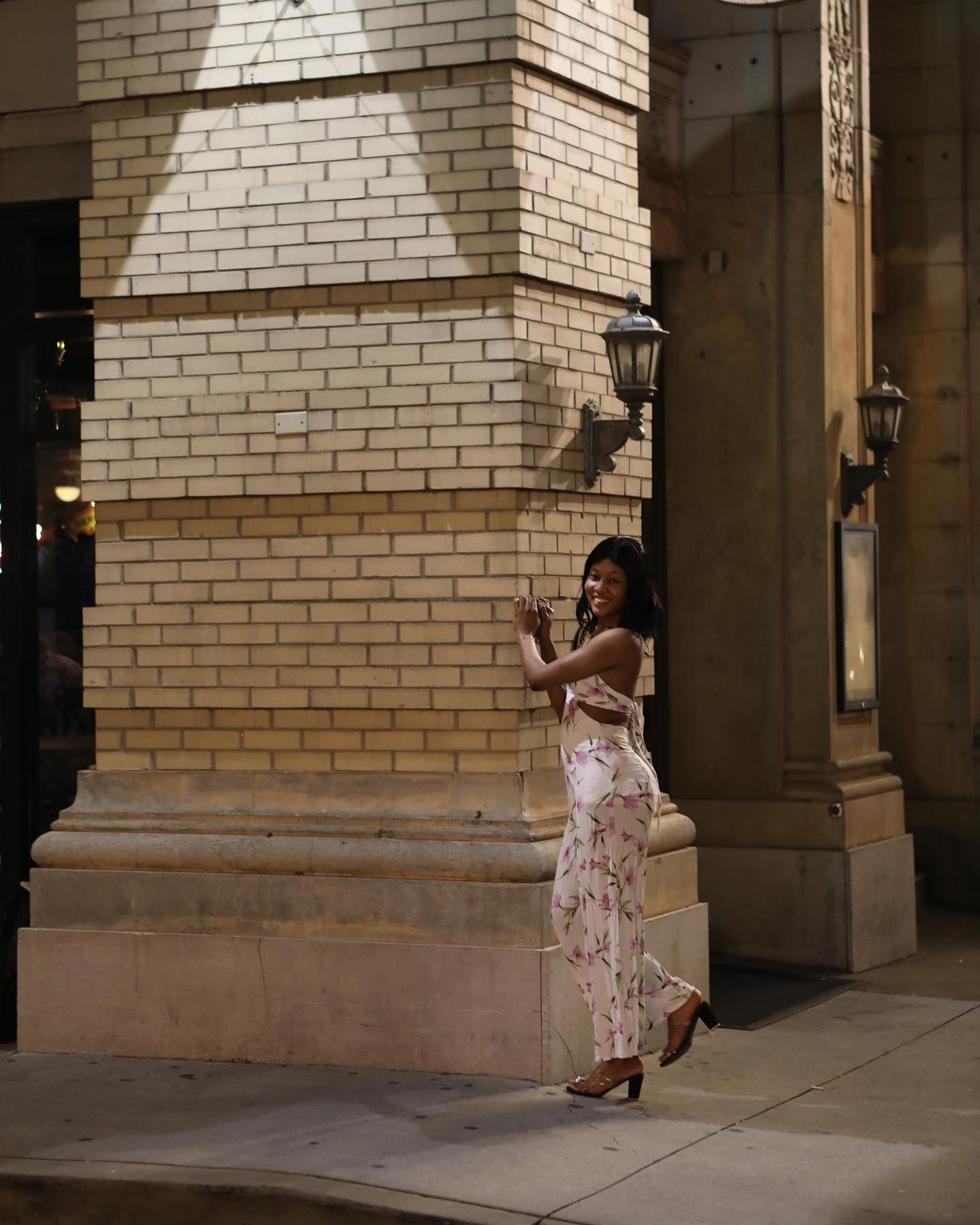 Environmental portrait near a downtown brick building and street lamps