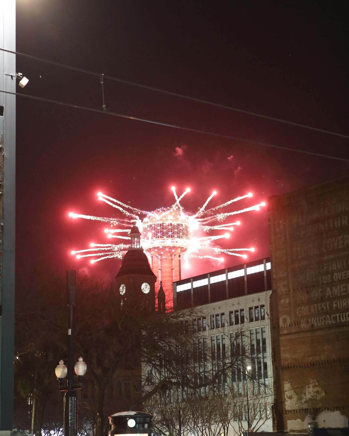 Red fireworks surrounding Reunion Tower during a downtown celebration